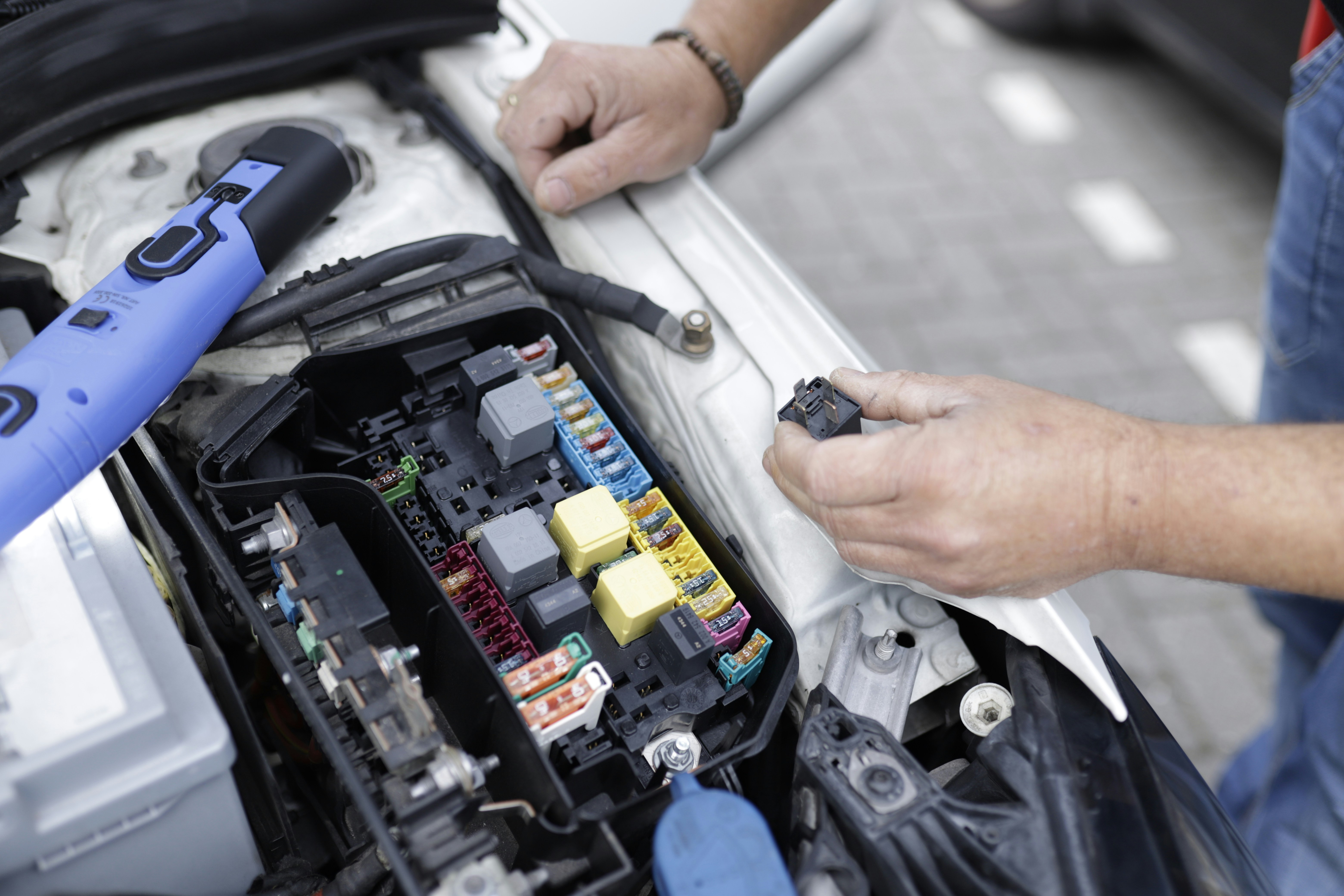 Mechanic working on vehicle fuse box