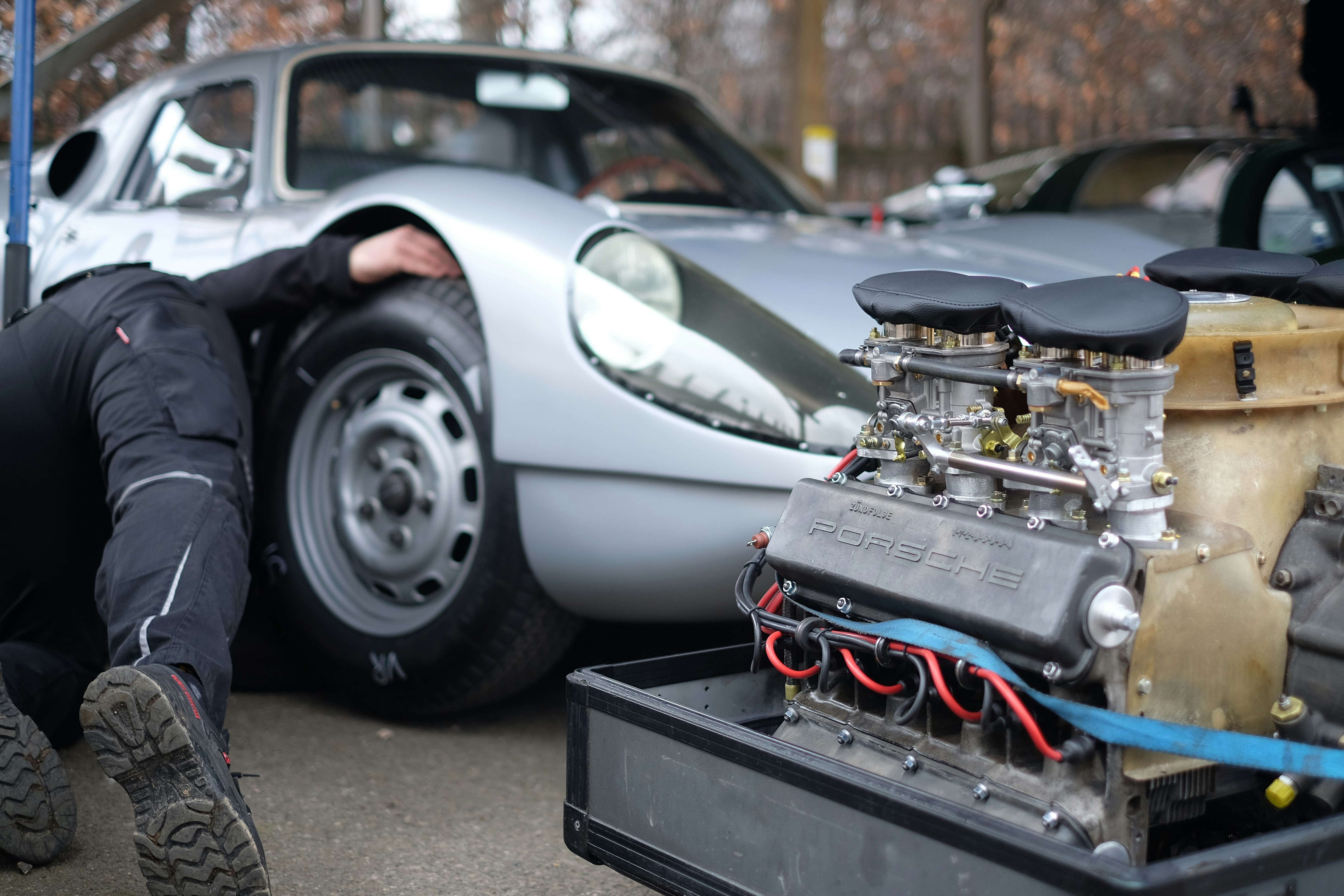 Mechanic working on classic Porsche outdoors